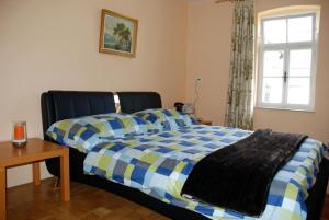 een slaapkamer met een bed met een blauw en geel dekbed bij Ruhig gelegenes Ferienhaus für erholsamen Urlaub auf dem Land inmitten der Thermenregion Sloweniens in Mala Nedelja