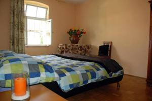 een slaapkamer met een bed en een vaas met bloemen bij Ruhig gelegenes Ferienhaus für erholsamen Urlaub auf dem Land inmitten der Thermenregion Sloweniens in Mala Nedelja
