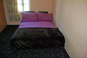 a bed with purple sheets and purple pillows at Ruhig gelegenes Ferienhaus für erholsamen Urlaub auf dem Land inmitten der Thermenregion Sloweniens in Mala Nedelja