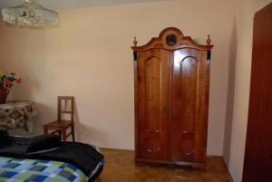 a large wooden cabinet in a bedroom next to a bed at Ruhig gelegenes Ferienhaus für erholsamen Urlaub auf dem Land inmitten der Thermenregion Sloweniens in Mala Nedelja