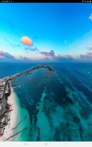 una vista aérea de la playa y del océano en Bote anclado libre sobre el arrecife lejos de la costa en Isla Mujeres