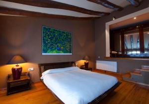 - une chambre avec un grand lit et une peinture murale dans l'établissement Masia Olivera, à Sant Pau dʼOrdal