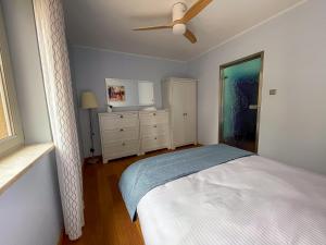 a bedroom with a bed and a ceiling fan at Surf&biKe apartments Jurata in Jurata