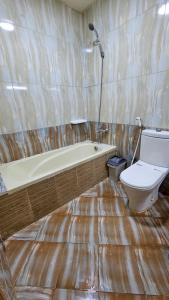 a bathroom with a bath tub and a toilet at Paradiso Backpackers Nest 1 in Abu Dhabi