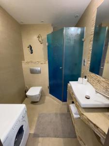 a bathroom with a sink and a washing machine at Surf&biKe apartments Jurata in Jurata