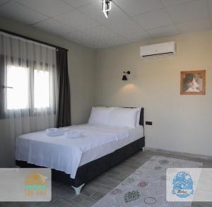a bedroom with a large bed and a window at Belize suit otel in Muğla