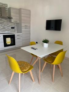 uma cozinha com uma mesa branca e cadeiras amarelas em Mimama em Telese Terme