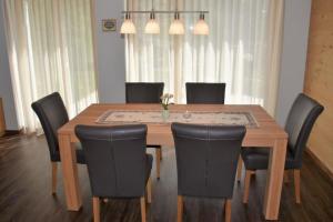 グリンデルワルトにあるHohturnen 35 Zimmer Wohnungのダイニングルームテーブル(黒い椅子付)