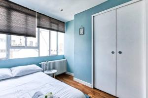 una camera con letto bianco e pareti blu di Appartement Love près des Grands Magasins - 6P a Parigi