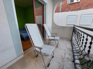 two white chairs sitting on a balcony at PEKOVIĆ in Bar