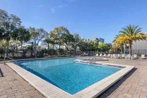 - une piscine dans un complexe avec des palmiers dans l'établissement Suburban Studios International Drive, à Orlando