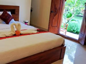 a bedroom with a bed with a stuffed animal on it at Majestic Heaven Retreat in Ubud