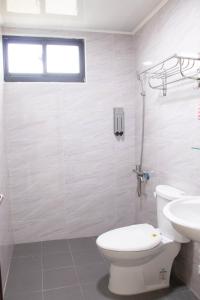 uma casa de banho branca com um WC e um lavatório em Island Man B&B em Huxi