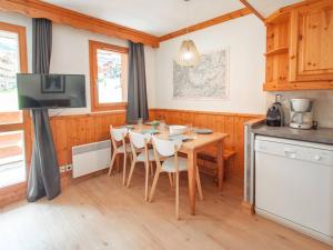 Il comprend une cuisine avec une table et des chaises ainsi qu'une télévision. dans l'établissement Appartement Valmorel, 3 pièces, 6 personnes - FR-1-291-754, à Valmorel