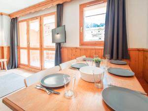 a dining room with a wooden table and a television at Appartement Valmorel, 3 pièces, 6 personnes - FR-1-291-754 in Valmorel