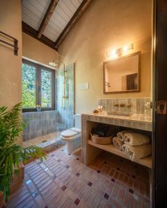 a bathroom with a sink and a toilet and a mirror at Eco Hotel Cueva del Gato in Benaoján