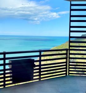 uma vista para o oceano a partir de uma varanda com uma cerca em Baia Vallugola Exclusive Apartment em Castel di Mezzo