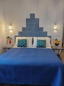a blue bed with a blue and white bedspread at Sosò Art b&b in Positano