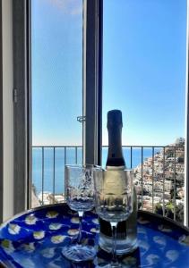 a table with two glasses and a bottle of wine at Sosò Art b&b in Positano