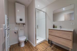 uma casa de banho com um WC, um chuveiro e um lavatório. em Le Nid em Poitiers