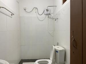 a white bathroom with a toilet and a shower at Richland's Villa in Kandy