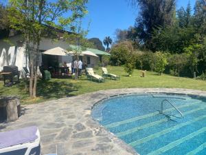 een zwembad in de tuin van een huis bij The White House - El Monte RM in Talagante