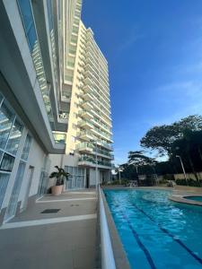 un gran edificio con una piscina al lado de un edificio en Centro de Convenções Riocentro - O melhor para mais de 2 hóspedes - Shows Rio de Janeiro, RioStay Flat - Cidade do Rock - Jeunesse Arena - Parque Olimpico - Apartamento Duplo Completo, en Río de Janeiro