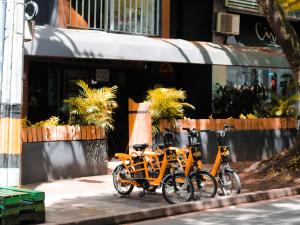 twee fietsen geparkeerd op een stoep voor een trein bij Tiger Hostel in Medellín