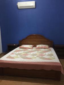 a blue bedroom with a bed with two pillows at Lucky Home Kandy in Ampitiya
