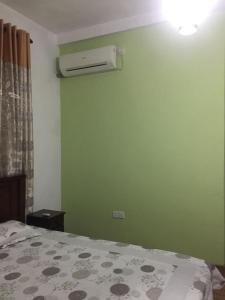 a bedroom with a green wall with a air conditioner at Lucky Home Kandy in Ampitiya
