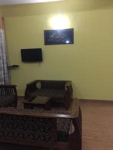 a living room with chairs and a television on the wall at Lucky Home Kandy in Ampitiya