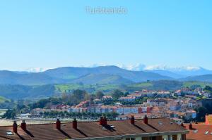 a view of a city with mountains in the background at Dúplex El Mochuelo: vistas al casco histórico, mucha luz y plaza de aparcamiento in San Vicente de la Barquera +19 photos