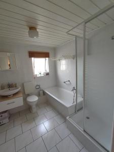ein Badezimmer mit einer Badewanne, einem WC und einem Waschbecken in der Unterkunft Ferienwohnung Zittauer Gebirge in Waltersdorf