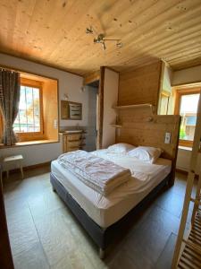 ein Schlafzimmer mit einem großen Bett und einer Holzdecke in der Unterkunft LA FERME DU FAY in Sixt