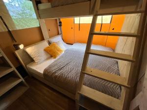 um pequeno quarto com um beliche e uma escada em Safari Lodge Grou, luxe kamperen op een eiland! em Grou
