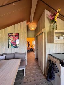 uma sala de estar com um sofá e uma mesa em Safari Lodge Grou, luxe kamperen op een eiland! em Grou