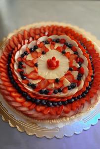 a cake with fruit on a plate on a table at Agriturismo Villa Bardi struttura con camere vista mare in Riva Trigoso