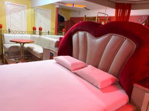 a bed with a heart shaped headboard in a room at Baviera Motel by Drops in Genuino Sampaio