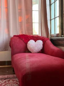 a red couch with a heart pillow on it at Evansville Holiday House in Evansville