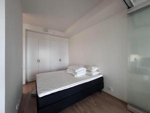 een slaapkamer met een bed met witte muren en witte kasten bij Upouusi luksusasunto! / Areena / Juna-asema /4hlö in Tampere