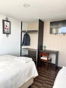 伊皮亞萊斯的住宿－TRÉBOL GOLDEN HOTEL，一间卧室配有书桌、一张床和一把椅子