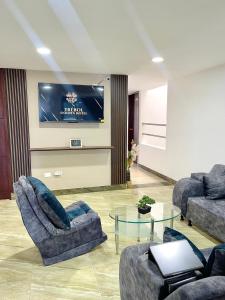 uma sala de estar com dois sofás e uma televisão em TRÉBOL GOLDEN HOTEL em Ipiales