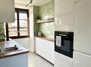 a white kitchen with a sink and a stove at Appartement centre ville Milly-la-Forêt in Milly-la-Forêt +8 photos