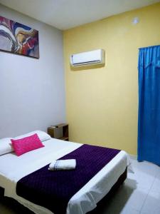 sypialnia z łóżkiem z fioletowym kocem w obiekcie RUTA DEL MAR INN HOTEL w mieście Santa Marta