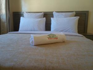 een bed met een handdoek erop bij Kulu Lodge Apartments in Lusaka