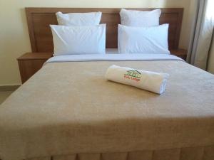 een hotelkamer met een bed met een kussen erop bij Kulu Lodge Apartments in Lusaka