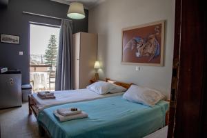 Un dormitorio con dos camas y una gran ventana. en Nefeli Rooms, en Agia Marina de Nea Kydonia