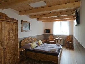 1 dormitorio con 1 cama, mesa y sillas en Bakony Kőhegy vendégház, en Csehbánya