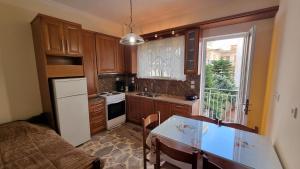 uma cozinha com armários de madeira, uma mesa e uma janela em Be Our Guest em Lepanto