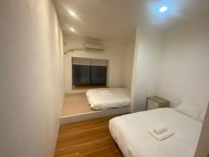 a small room with two beds and a window at 新宿家族連れ４LDKの子供つれ5星 in Tokyo